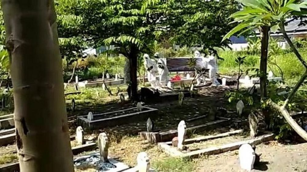 Tangkapan layar petugas pemulasaran jenazah yang menggunakan APD membawa kembali jenazah yang tertukar di salah satu TPU di Surabaya.

Foto: SP/repro patrick