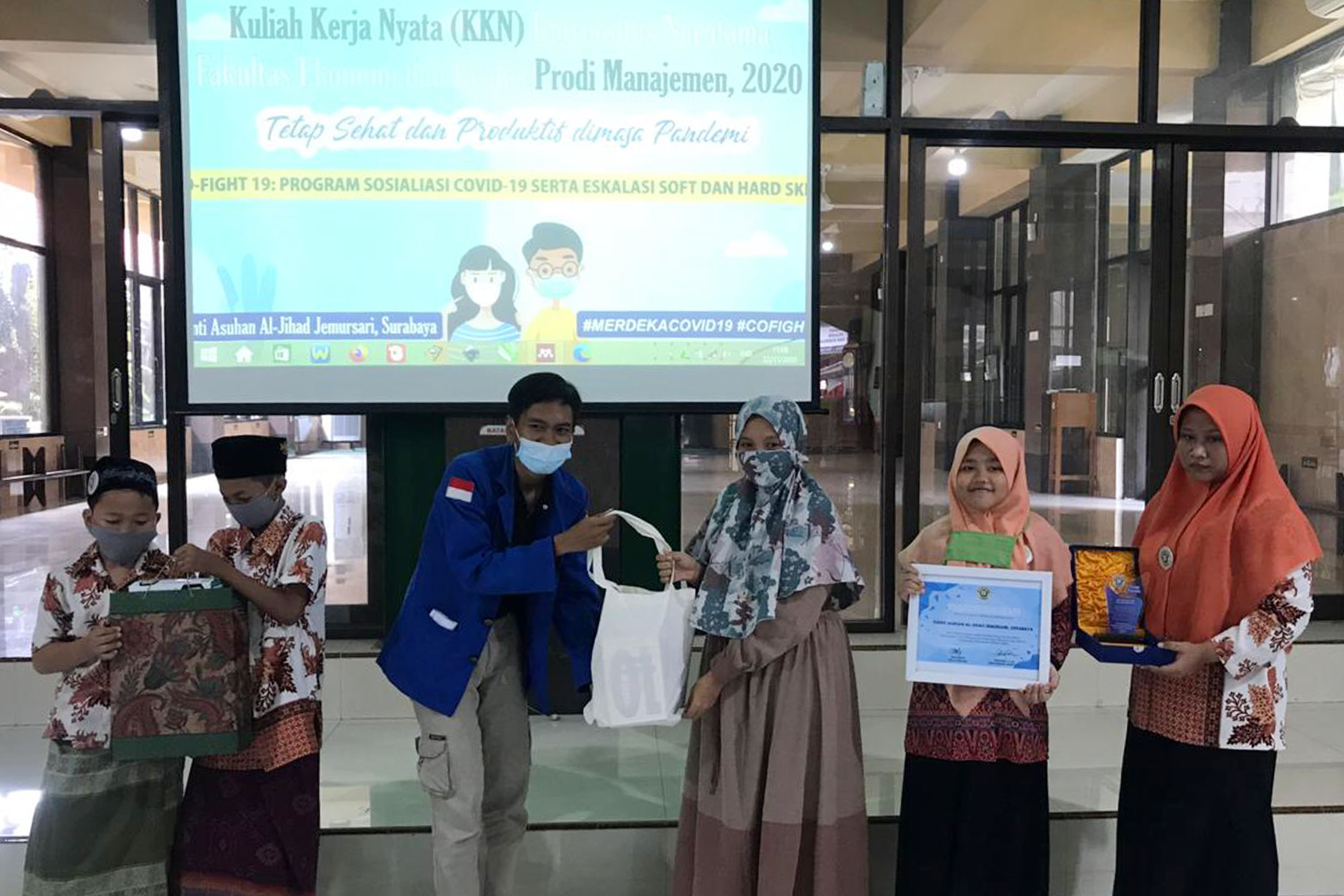 Bagus Pramudita selaku Ketua KKN memberikan hadiah berupa cindera mata pada anak Panti Asuhan Al-Jihad di   Panti Asuhan Al Jihad, Jemursari, Surabaya, Minggu (22/11).SP/Patrik Cahyo