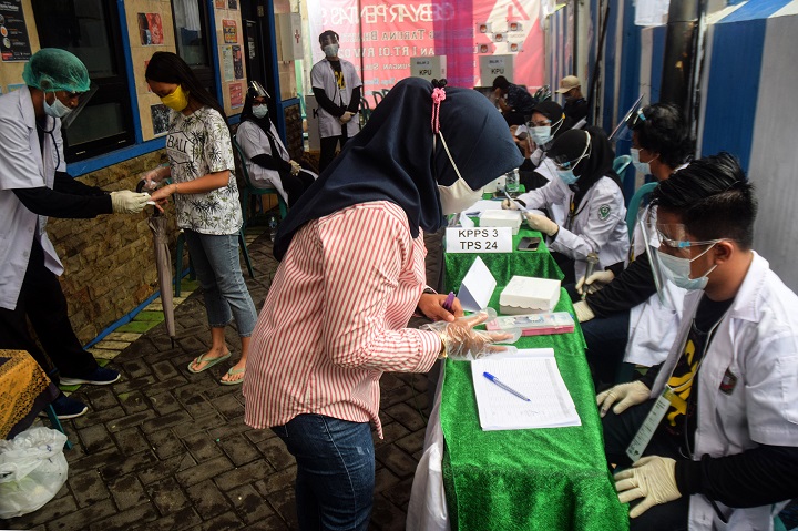 Petugas KPPS menggunakan jaket medis saat pencoblosan di salah satu TPS. SP/Patrik Cahyo