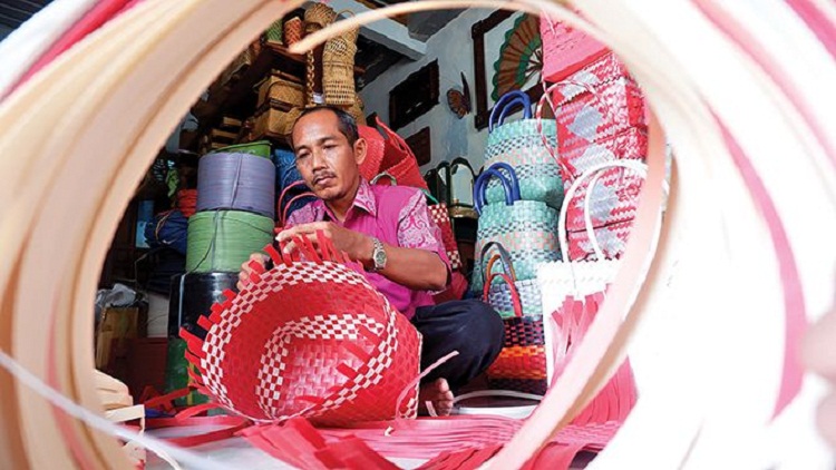 Kamirin yang sedang membuat anyaman plastik di rumahnya. SP/ TLG