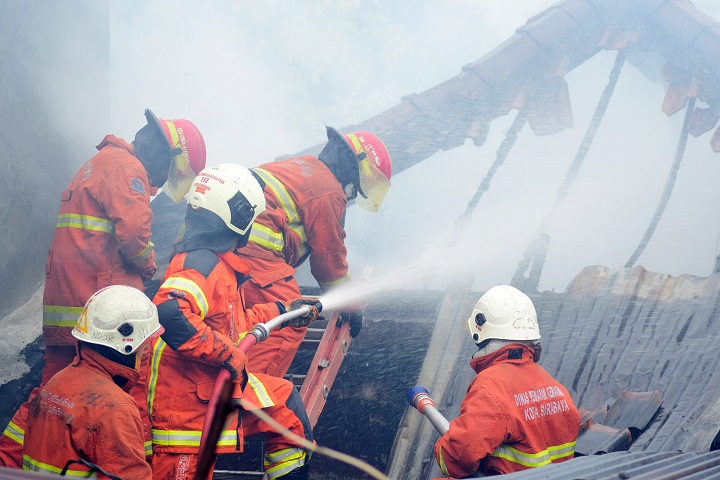 Petugas pemadam kebakaran (Damkar) melakukan pembasahan rumah warga yang terbakar di permukiman padat penduduk di Simolawang Pojok, Jumat (20/11/2020). SP/Patrick