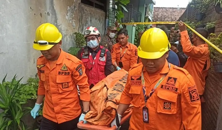 Petugas BPBD Surabaya saat mengevakuasi korban meninggal dunia saat rumah di Jalan Menanggal Surabaya terbakar. SP/Ariandi