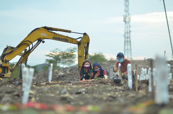 Sejumlah peziarah mendatangi makam salah satu kerabat yang baru saja dimakamkan di TPU Keputih khusus Covid-19, Minggu (15/8/2021). Sp/arl