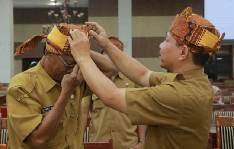 Kepala Diskominfo Kabupaten Probolinggo Yulius Christian memasangkan udeng kepada salah satu anak buahnya. SP/ PRB