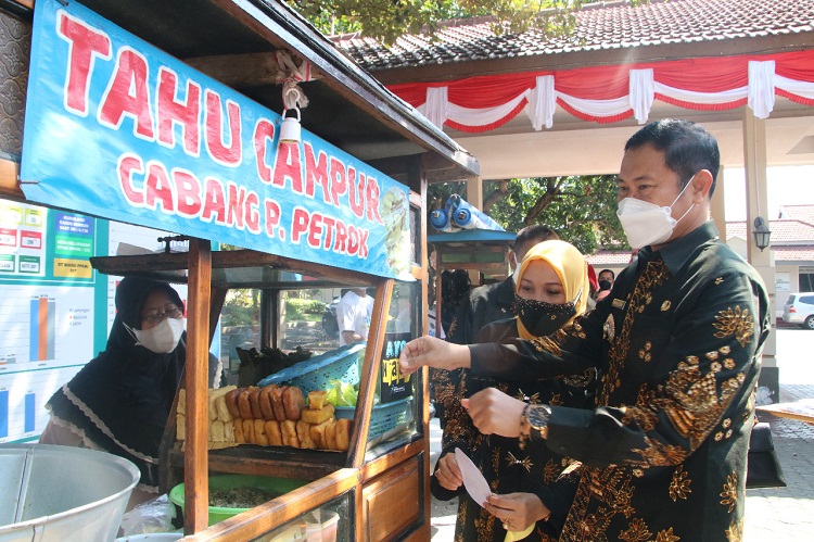 Bupati Yuhronur Efendi menempeli stiker "Ayo Numbasi" di rombong pedagang kali lima. SP/MUHAJIRIN KASRUN