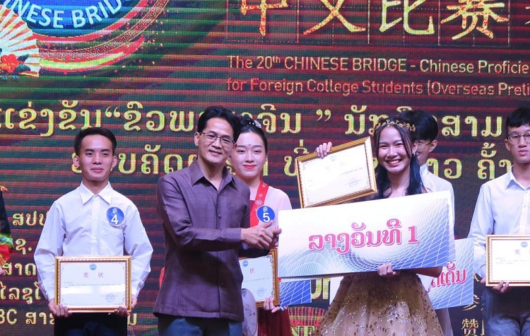 Viengnakhone Vongvixai (kanan, depan) dari Fakultas Sastra Universitas Nasional Laos (NUOL) menyerahkan penghargaannya kontes "Jembatan Cina" ke-20. SP/ CH