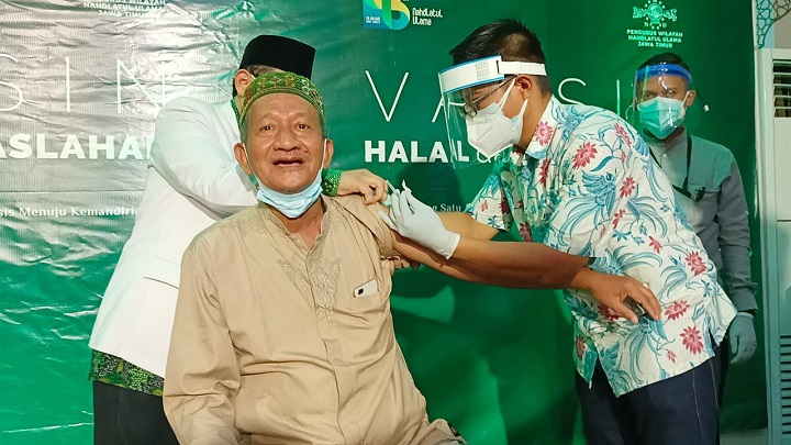 Ekspresi KH Agoes Ali Masyhuri saat disuntik vaksin Covid-19 Sinovac di kantor PWNU Jatim, Selasa (23/2/2021).  SP/Arlana