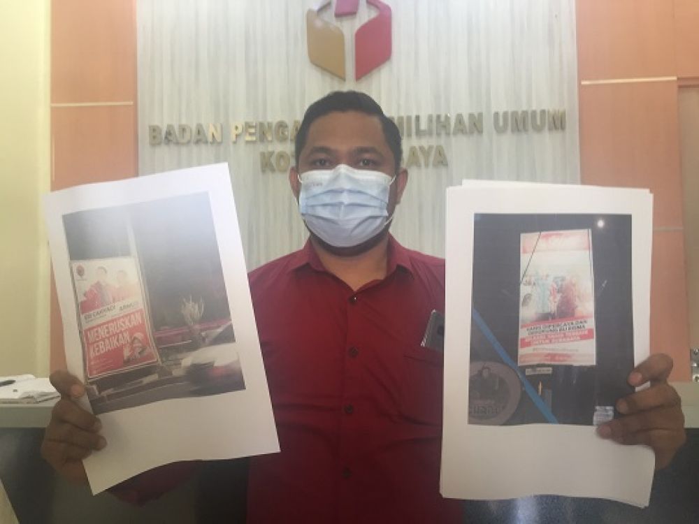Ketua KIPP Novly Thysson, menunjukkan dua bukti yang jadi laporan ke Bawaslu Kota Surabaya, kemarin. Sp/alqomar