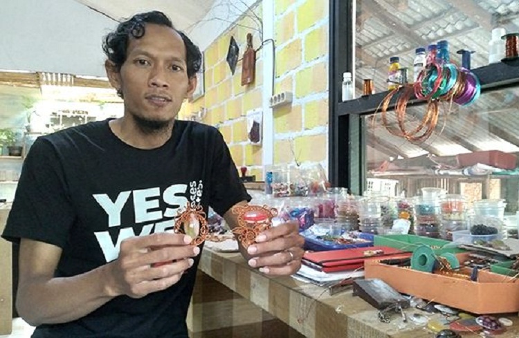 Mashun menunjukkan bros berhias batu alam karyanya. SP/ BLT