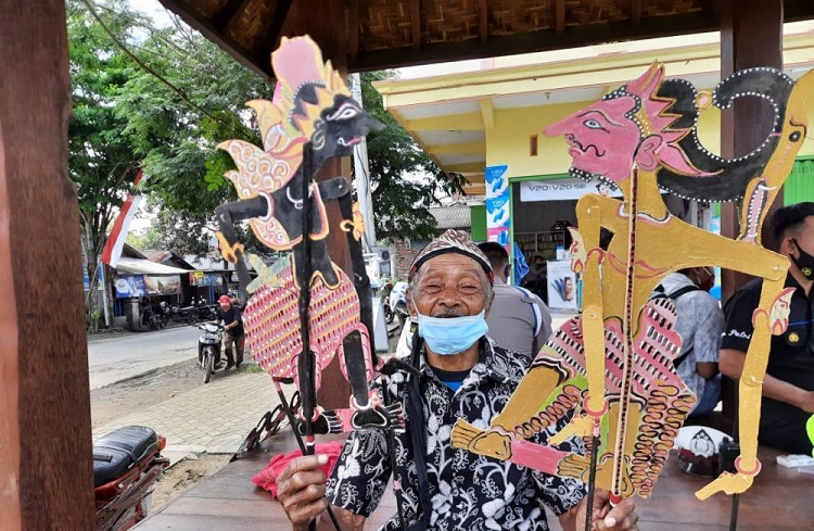 Mbah Samsudin memamerkan wayang kertasnya. SP/ TRG