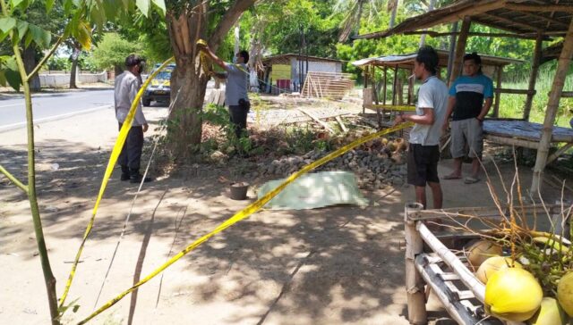 Petugas memasang garis polisi di lokasi penemuan jasad ODGJ.