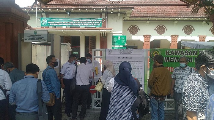 Terlihat sejumlah pengunjung di depan gerbang Pengadilan Negeri (PN) Surabaya dan security tak henti-hentinya mengimbau PN Surabaya lockdown selama dua pekan , Senin (18/1/2021).SP/BUDI MULYONO