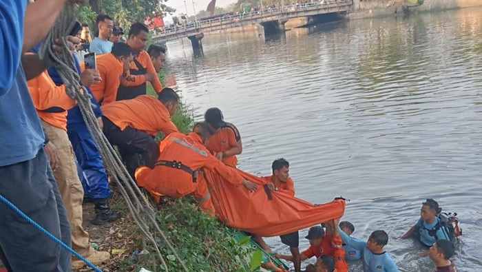 Petugas Command Center 112 BPBD Surabaya saat menyelamatkan dua orang yang melarikan diri dari aksi tawuran di Jembatan Petekan Surabaya, Senin (22/5/2023).
