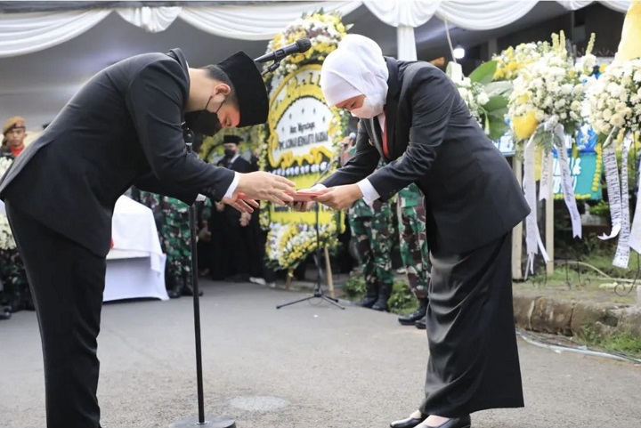 Gubernur Jatim Khofifah Indar Parawansa memberikan map saat sebagai inspektur upacara dalam pemakaman ayah Wakil Gubernur Emil Dardak di TMP Kalibata Jakarta, Minggu (21/8/2022).