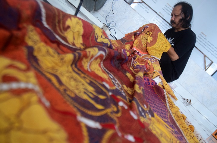 Pengki, pembina Rumah Batik di kawasan eks lokalisasi di Jalan Putat Jaya sedang menyelesaikan canting pada kain batik di Rumah Batik. Sp/Patrick