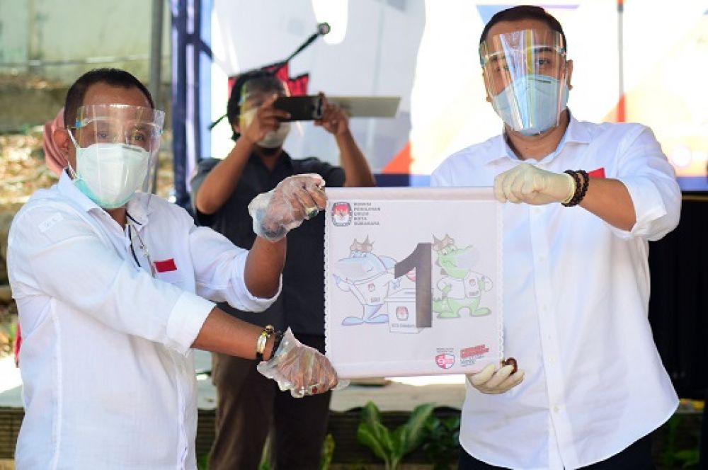 Paslon Eri Cahyadi dan Armuji, menunjukkan nomor urut 1 saat pengundian di Hotel Singgasana Surabaya, Kamis (24/9/2020).