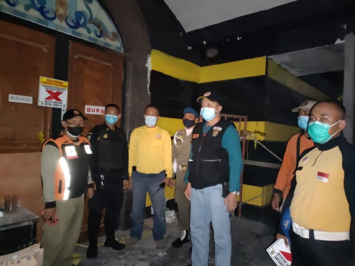 Petugas saat menyegel salah satu tempat hiburan yang nekat beroperasi di tengah penerapan PPKM.