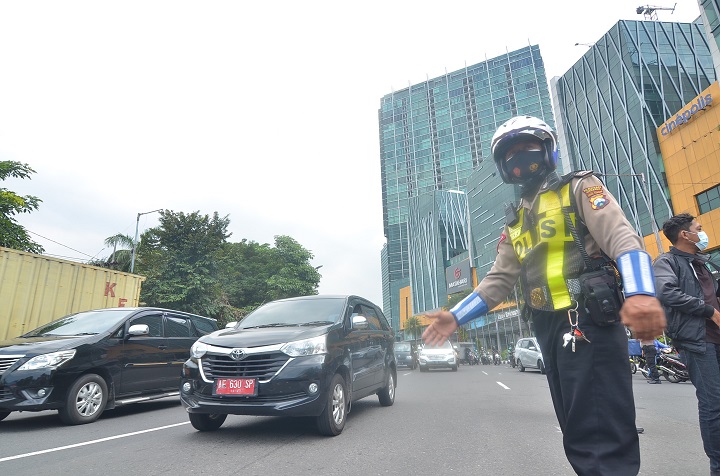 Petugas kepolisian yang dipimpin Kakorlantas Polri Irjen Istiono, bersama jajarannya mengarahkan kendaraan pribadi yang melintas di jalur keluar masuk Kota Surabaya di Bundaran Waru perbatasan Surabaya, Kamis (29/4/2021). SP/Arlana