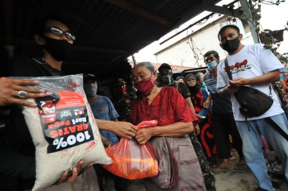 Sejumlah warga Surabaya menerima pembagian bantuan di kawasan Ambengan Selatan Karya RW 5 Kelurahan Pacar Keling, Surabaya, Jawa Timur, Minggu (10/5/2020). Julian
