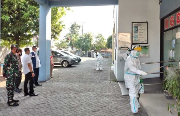 Petugas menyemprotkan disinfektan untuk mensterilisasi puskesmas.