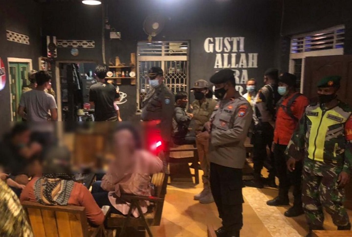 Petugas saat mendatangi salah satu warkop yang masih buka meski telah melewati aturan jam malam PPKM Darurat.