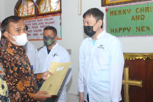 Karutan Gresik, Aris Sakuriyadi menyerahkan SK Kemenkum-HAM secara simbolis kepada warga binaan yang mendapat remisi Natal di gereja di lingkungan Rutan.