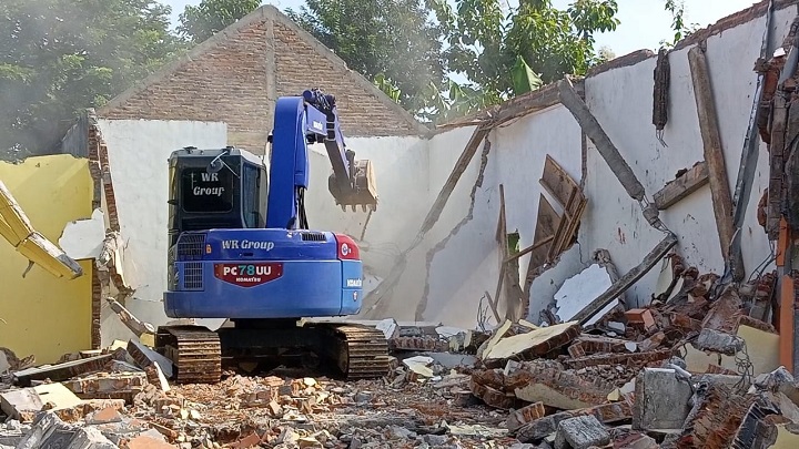 Proses penghancuran rumah yang menggunakan backhoe.