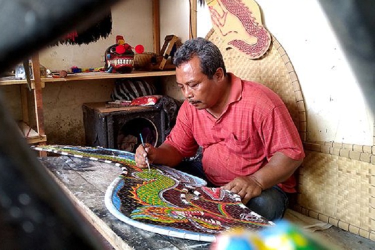 Samirin saat mengecet properti kuda lumping buatannya. SP/ TLG