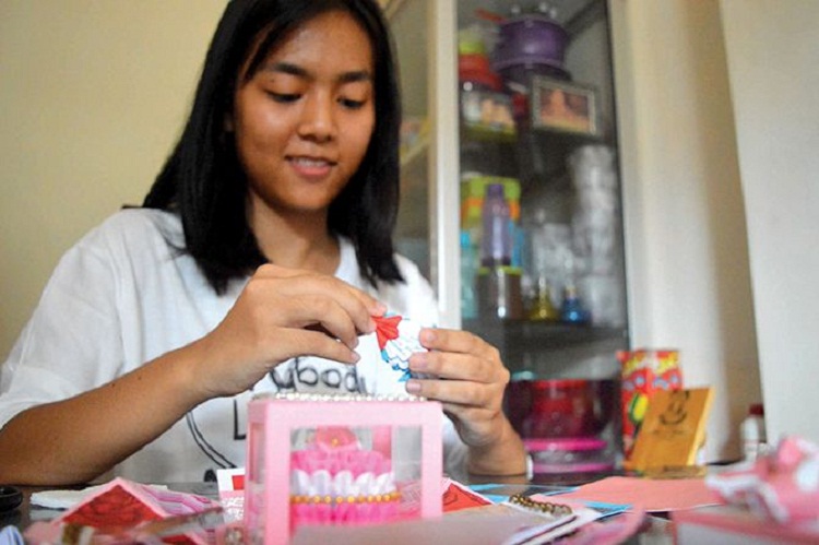 Sarah Aurelia Kristian yang sedang mengerjakan explosion box pesanan pelanggannya. SP/ TLG