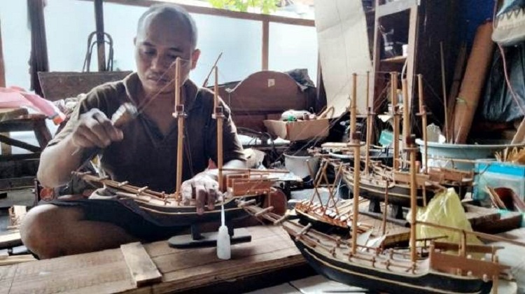 Sunali saat mengerjakan miniature kapal pesanan pelanggannya. SP/ MJK
