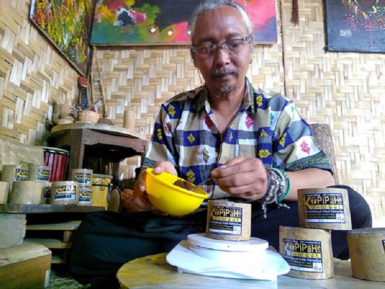 Arsdyansyah ketika menakar kopipahe dalam glodok bambu. SP/ TRG