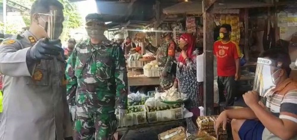 Kapolres Blitar Kota AKBP Leonard membagikan Face Shield ke pedagang di pasar tradisional. SP/Les