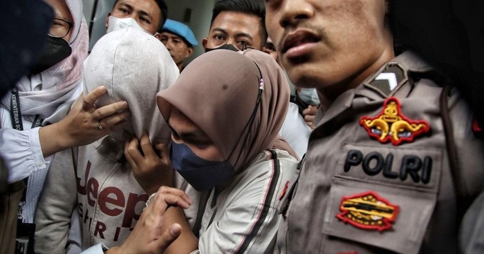 Anak AG, pacar Mario Dandy, menghindari kejaran wartawan dan fotogfer, dengan wajah ditutupi penutup jaket, usai menjalani vonis di Pengadilan Negeri Jakarta Selatan, Senin (10/4/2023).