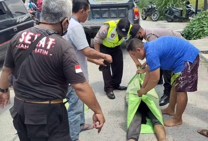 Petugas mengevakuasi jenazah korban. 