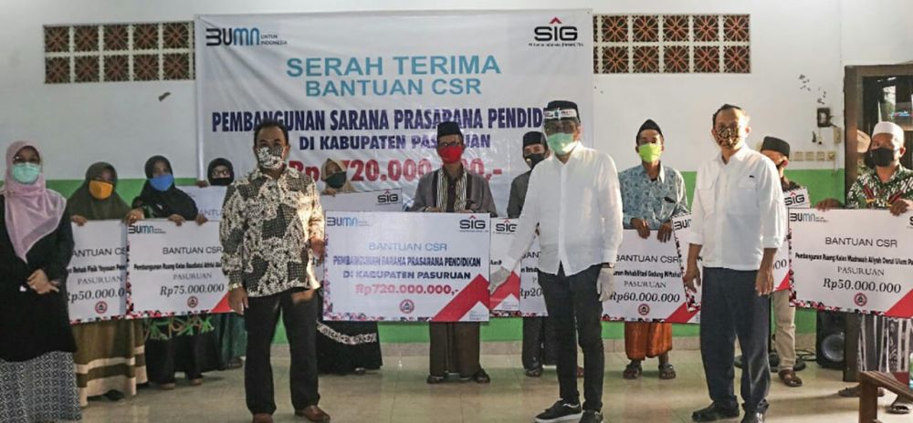 General Manager of CSR SIG Edy Saraya (berbaju batik) menyerahkan bantuan untuk pembangunan gedung dan ruang kelas baru di Kabupaten Pasuruan, Jatim dan Bogor, Jabar. SP/SIG