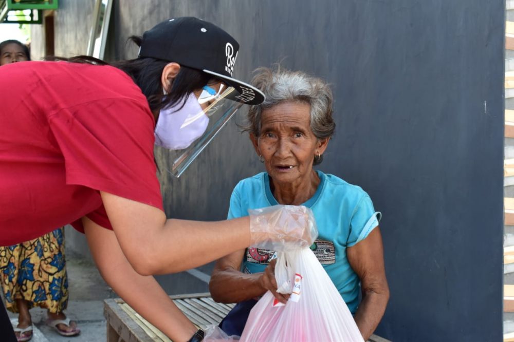 Salah satu perwakilan SNA membagikan paket sembako kepada masyarakat.