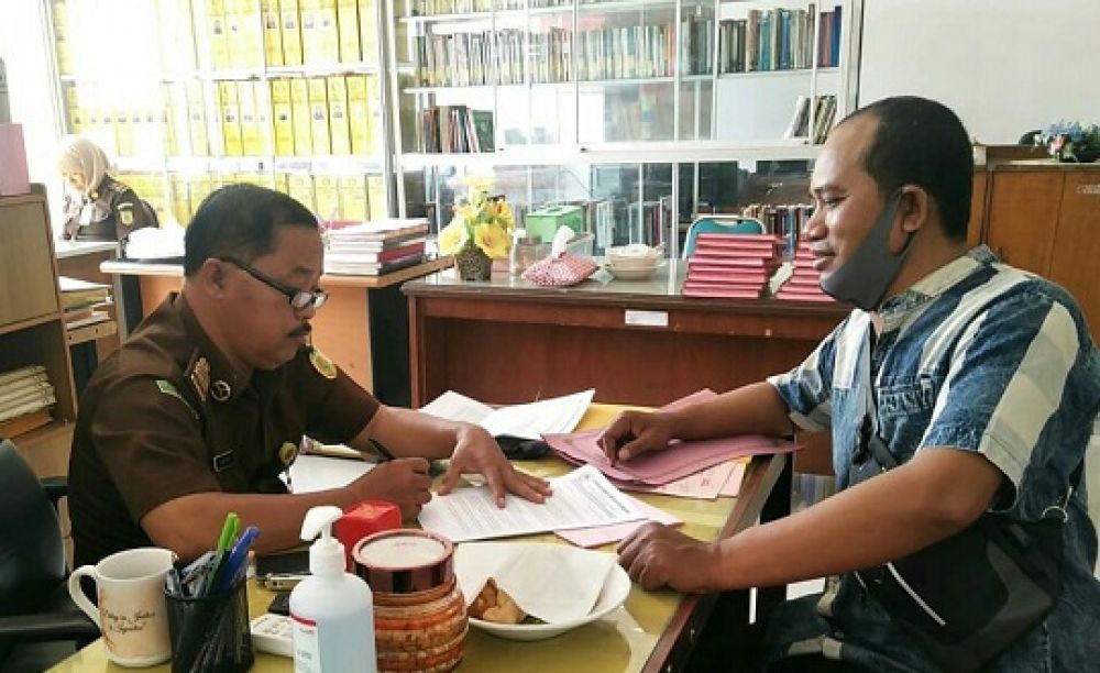 Charif Anam saat menyerahkan laporan yang diterima Kasubag TU Kejari Gresik Arifin SH.SP/M.AIDID