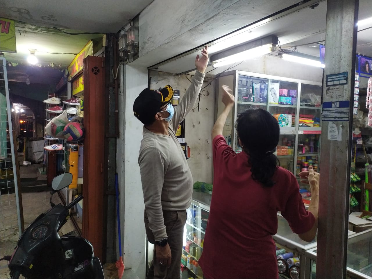 Dodot membantu penjaga toko untuk segera berkemas menutup lapaknya . SP/ANGGADIA MUHAMMAD