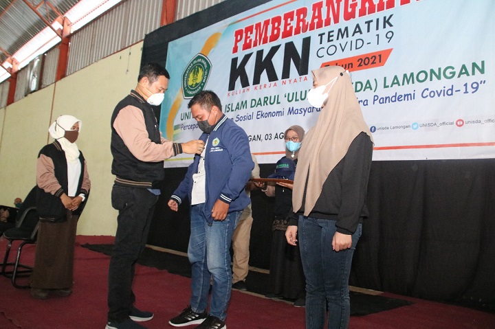 Bupati Yuhronur Efendi saat memakaikan jaket KKN kepada mahasiswa. SP/MUHAJIRIN KASRUN