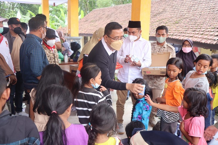 Ketua DPW Partai Gerindra Anwar Sadad bersama anak-anak pengungsi korban erupsi Gunung Semeru di Lumajang, Minggu (5/12/2021). SP/Riko Abdiono