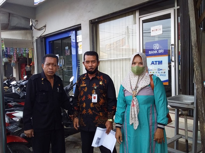Busa'i bersama istrinya Asrifah didampingi ketua LPH RI Drs. Ec. Moh. Anwar SH berpose di depan Kantor BRI Unit Lenteng. (SP/Ainur Rahman)