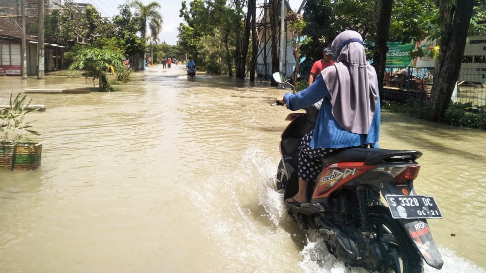 Kondisi jalan poros desa yang terendam banjir luapan kali Pacal.