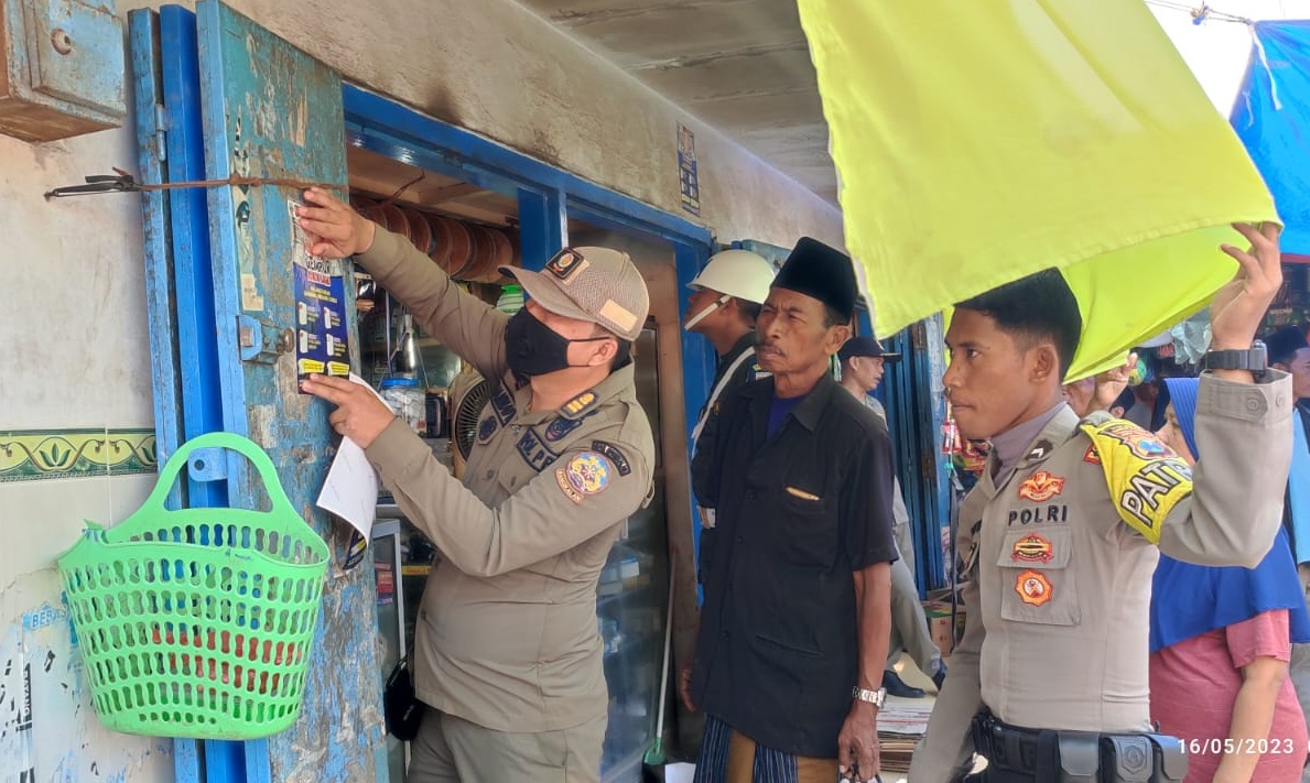 Satpol PP bersama instansi terkait saat menempel stiker gempur rokok ilegal di Pasar Arosbaya Bangkalan.