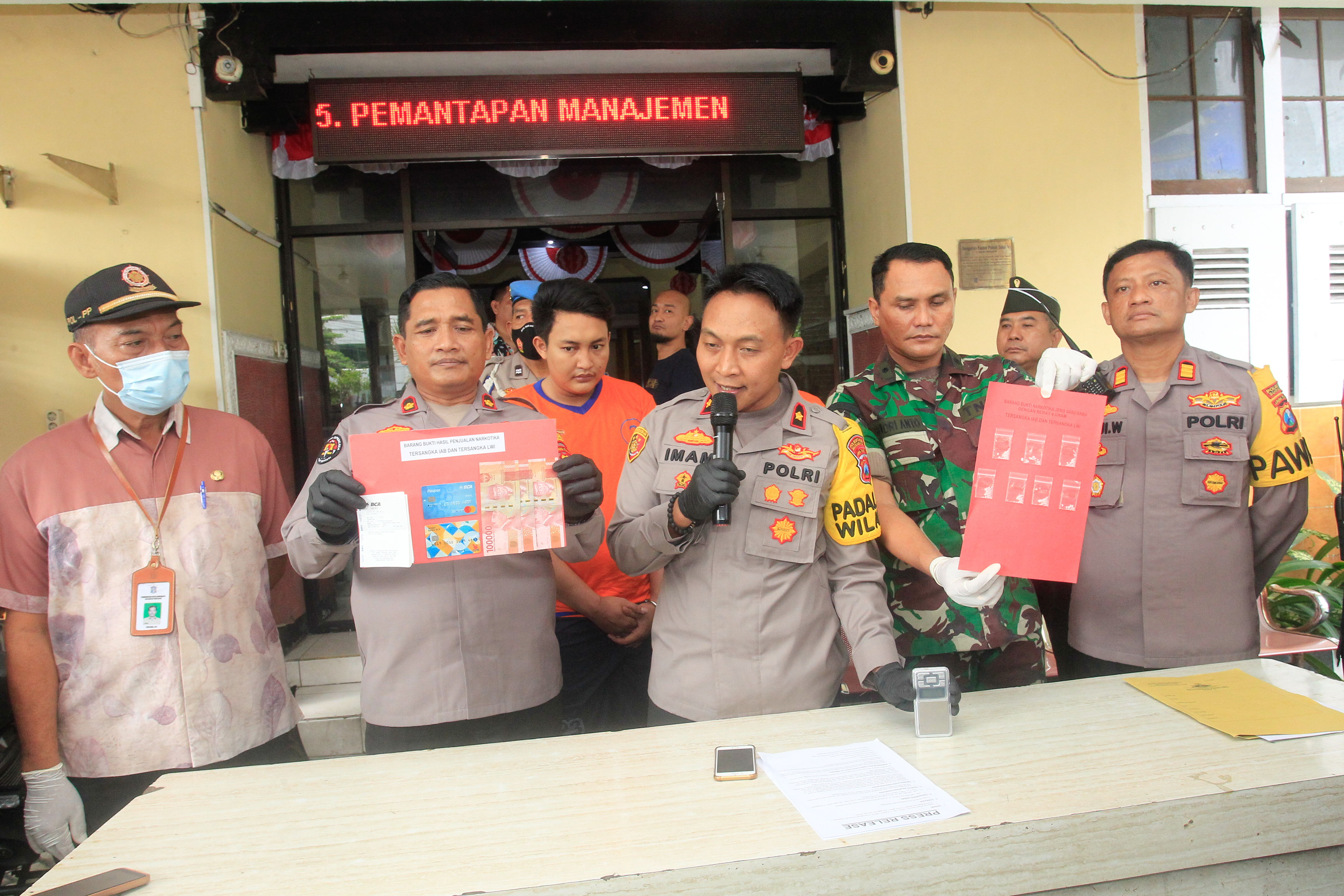 Tersangka dan barang bukti yang dipamerkan petugas kepolisian Polsek Tegalsari Surabaya, Kamis (26/1/2023). SP/Ariandi.