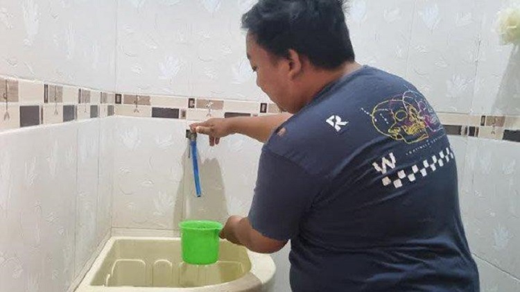 Salah satu warga Perum Permata Suci (PPS) Manyar Gresik menunjukkan air PDAM tidak mengalir dari keran di rumahnya. SP/ GRS