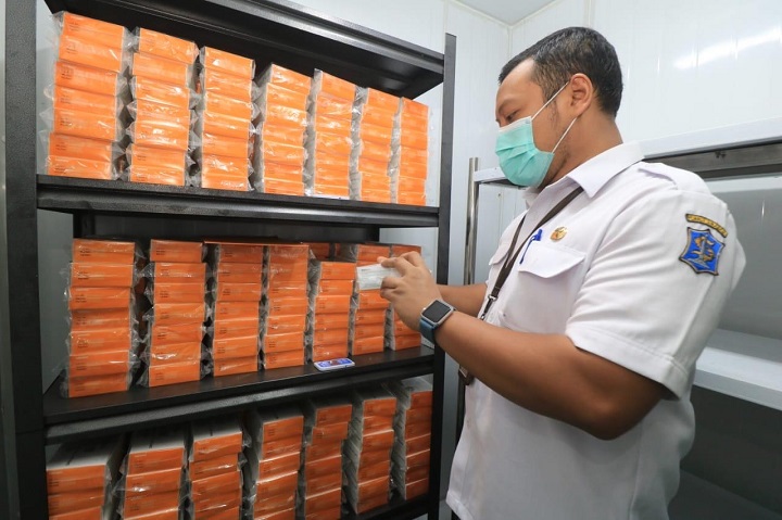 Petugas teengah memeriksa stok vaksin covid-19