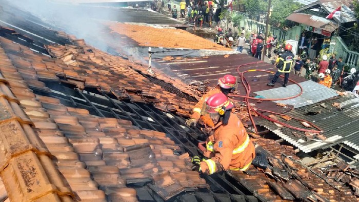 Petugas pemadam memadamkan api yang membakar 11 rumah di Kodam Surabaya