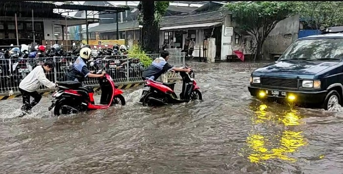 Beberapa pengendara motor yang nekat melewati banjir menuntut motornya karena mogok.