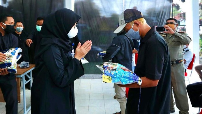 Bupati Banyuwangi Ipuk Fiestiandani menyerahkan bantuan kepada salah satu pelaku wisata.