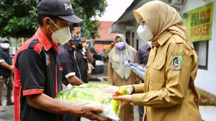 Bupati Banyuwangi Ipuk Fiestiandani menyerahkan bantuan kepada tukang pijat di halaman Posko Satgas Penanganan Covid-19 Kabupaten Banyuwangi, Senin (2/8).